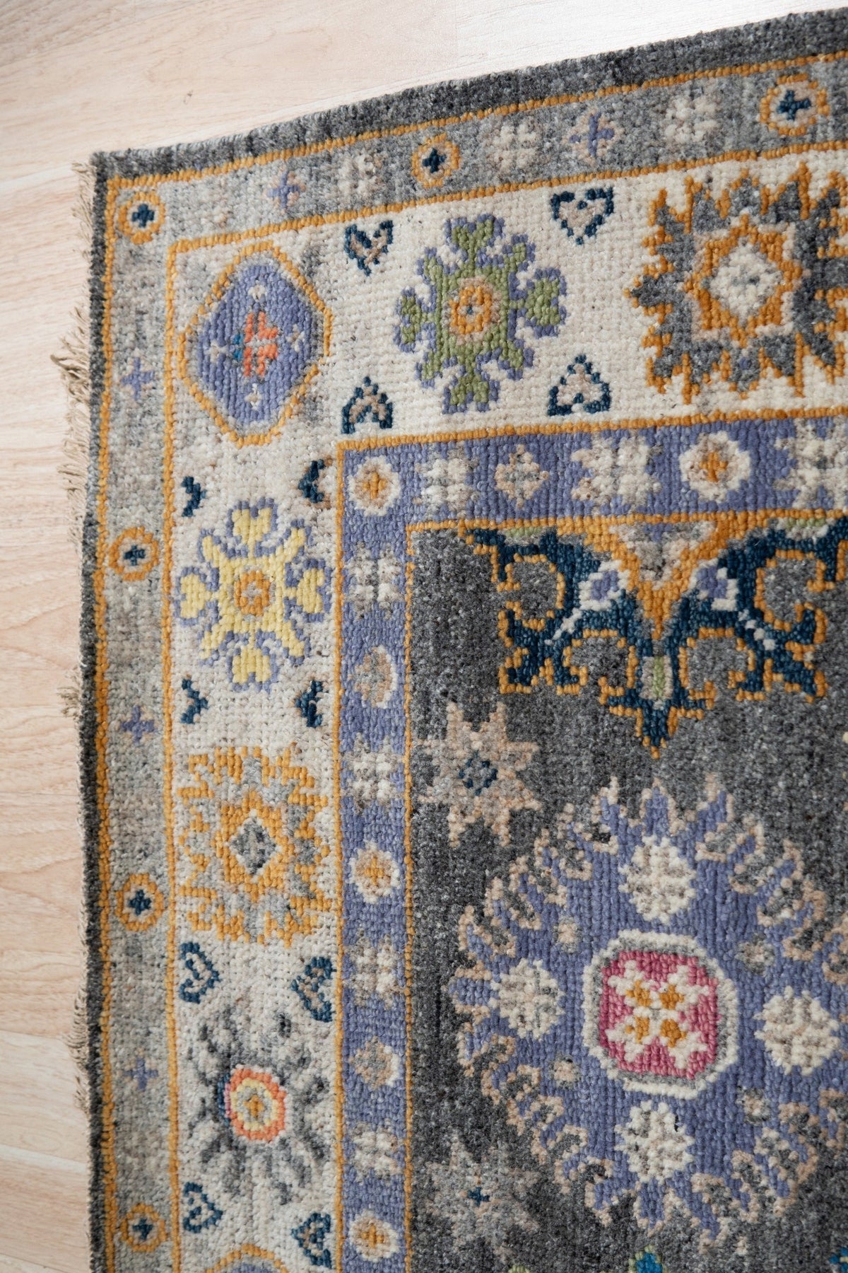 Lila Ruby Charcoal Hand Knotted Wool Rug, showing deep charcoal hues interwoven with subtle ruby accents. Hand-knotted construction creates a luxurious texture and intricate pattern across the wool pile.