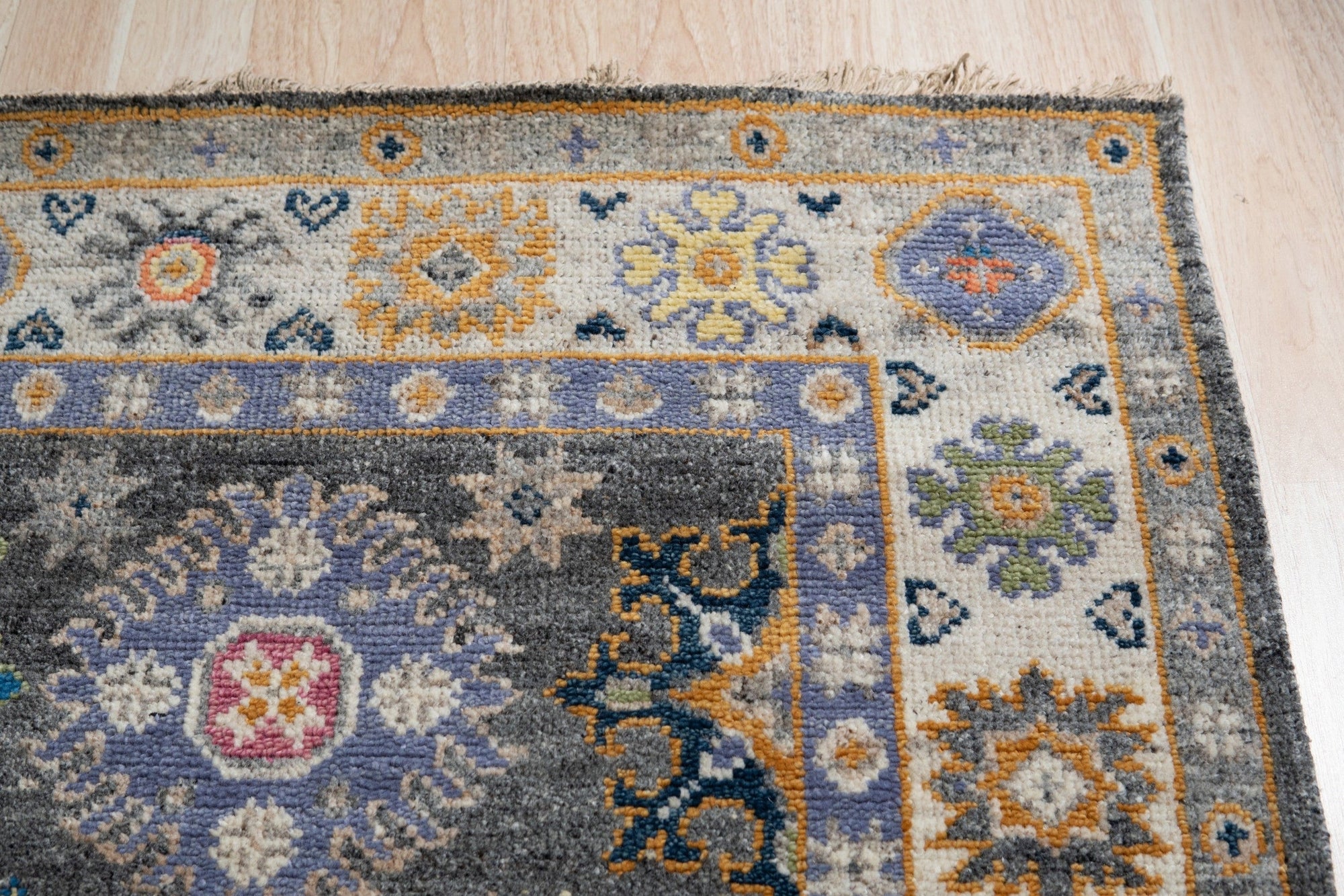 Lila Ruby Charcoal Hand Knotted Wool Rug, showing rich textural depth and subtle tonal variations in charcoal and ruby hues. Hand-knotted construction offers durability and a luxurious feel underfoot.