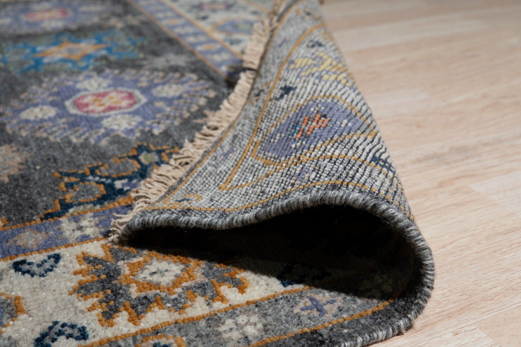 Lila Ruby Charcoal Hand Knotted Wool Rug in a bright living room setting. Charcoal and ruby tones create subtle contrast in the hand-knotted wool rug, anchoring a modern space with warm textures.