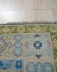 Maya Kazak Charcoal Hand Knotted Wool Rug, blending charcoal hues and traditional Kazak patterns, graces a modern living space with its hand-knotted wool texture and sophisticated warmth.