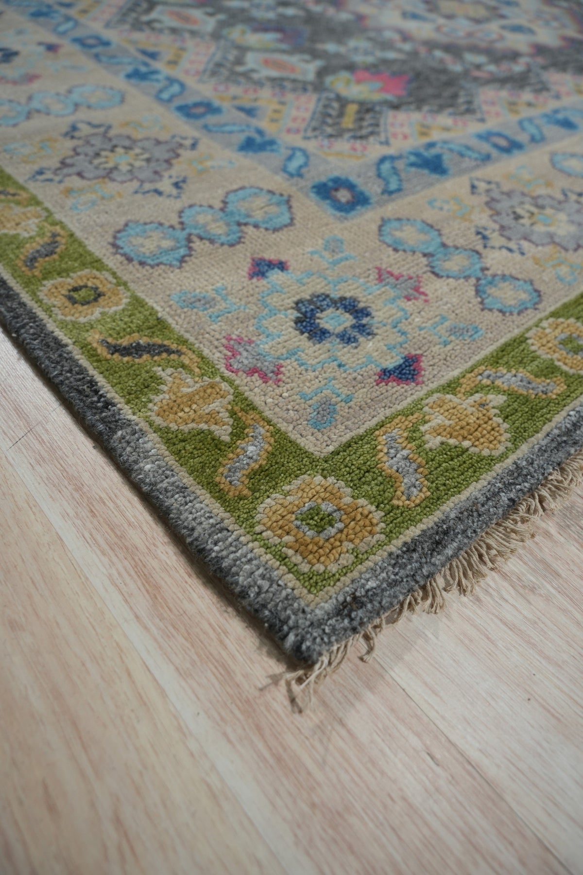 Maya Kazak Charcoal Hand Knotted Wool Rug, its rich charcoal hues and hand-knotted wool construction lending texture and depth to a warmly lit interior space.
