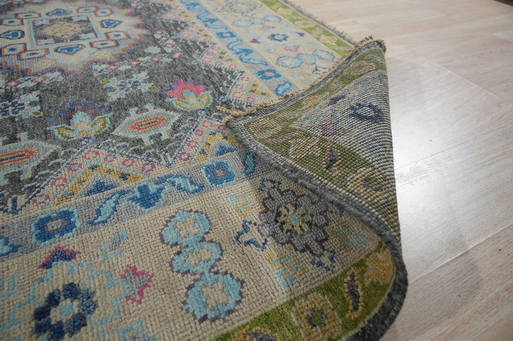 Maya Kazak Charcoal Hand Knotted Wool Rug, a dark charcoal wool rug with traditional Kazak patterns, displayed in a home setting with furniture.