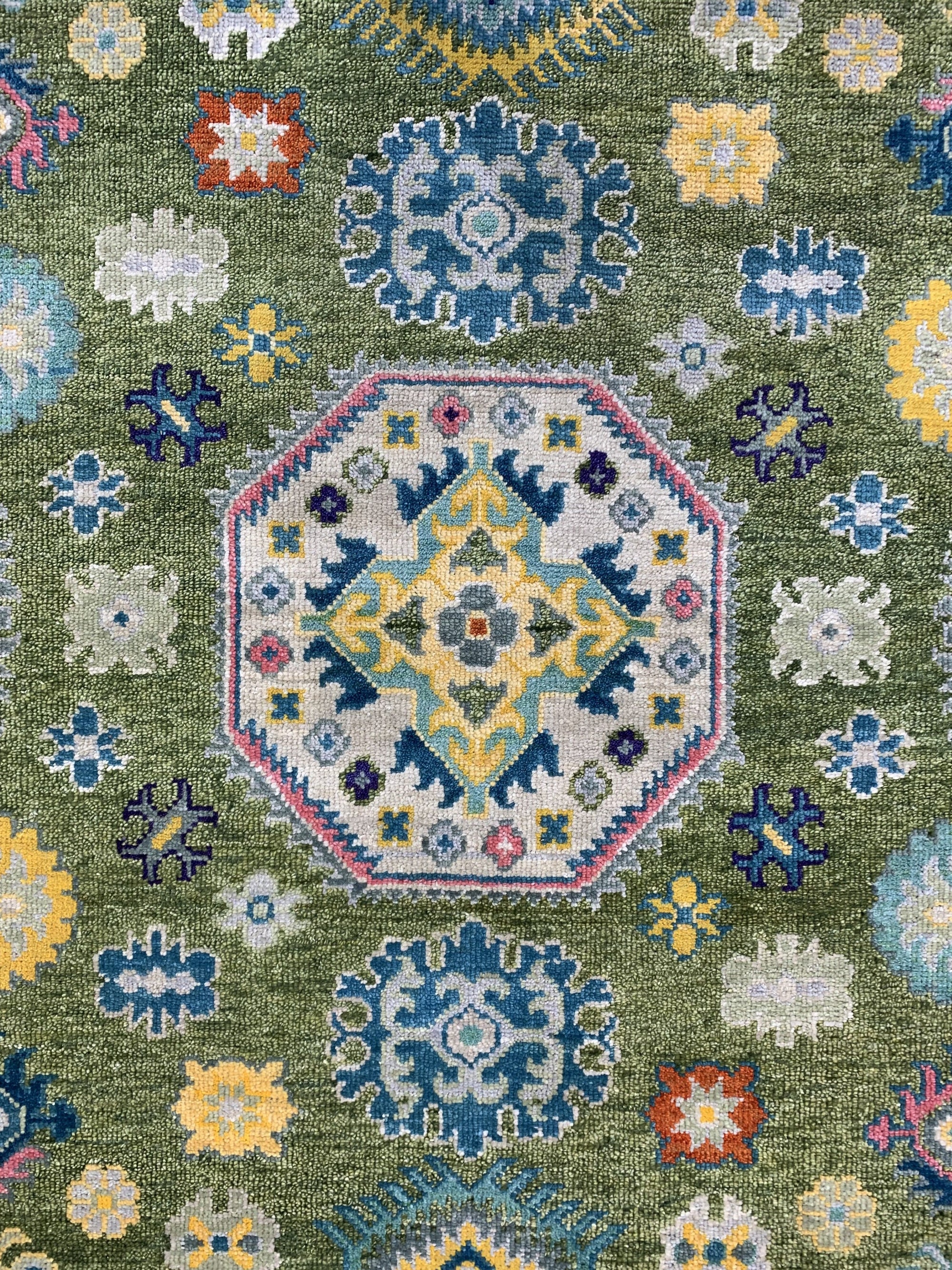 Inviting Kazak Light Green Hand Knotted Wool Rug, displaying a traditional geometric pattern in light green, ivory, and terracotta tones, anchoring a living room setting with classic elegance.