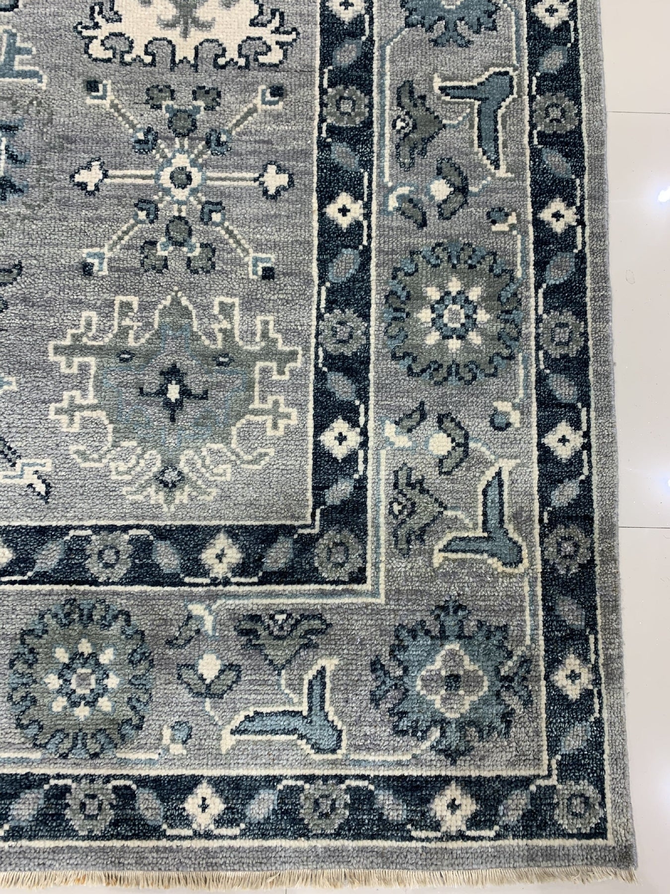 Maya Oushak Silver Hand Knotted Wool Rug, its silvery hues and intricate floral design softly illuminating a light-filled room.