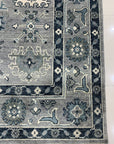 Maya Oushak Silver Hand Knotted Wool Rug, its silvery hues and intricate floral design softly illuminating a light-filled room.