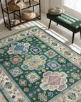 Isla Kazak Green Hand Knotted Wool Rug, showcasing intricate geometric patterns in shades of green and ivory, lies flat on a light-colored floor, emanating warmth and traditional elegance in a room setting.