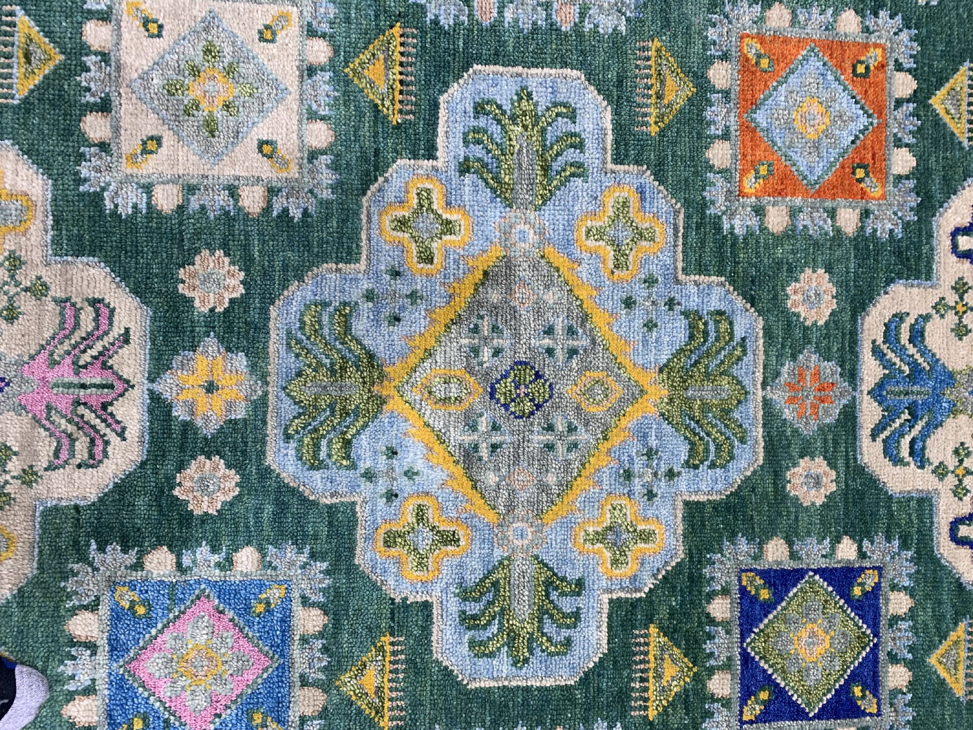 Isla Kazak Green Hand Knotted Wool Rug, vibrant green and earthy tones coalesce in a hand-knotted wool rug featuring a traditional Kazak pattern, creating a warm and inviting space.
