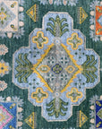 Isla Kazak Green Hand Knotted Wool Rug, vibrant green and earthy tones coalesce in a hand-knotted wool rug featuring a traditional Kazak pattern, creating a warm and inviting space.