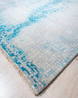 Stylish Sumptuous Aqua Hand Knotted Wool Rug, its cool aqua tones and hand-knotted texture enriching a bright, modern living space with a light wood floor.