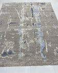 Clara Stylish Gray Hand Knotted Wool Rug, soft gray wool pile featuring a subtle geometric pattern, partially visible showcasing texture and construction.