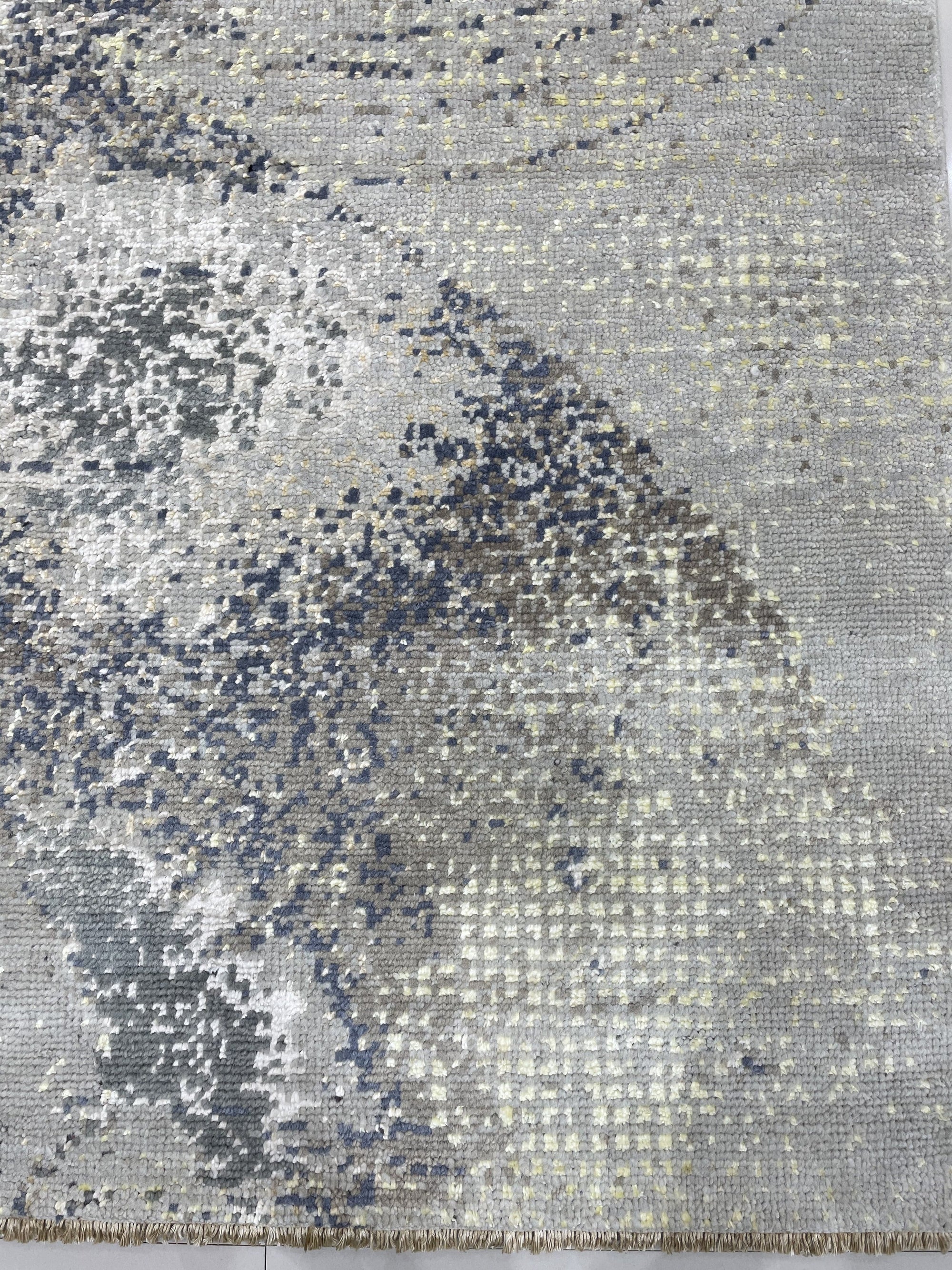 Lydia Cassandra Gray Hand Knotted Wool Rug, a sophisticated gray wool rug featuring a subtle, hand-knotted design, laid on a light hardwood floor, evoking a sense of understated elegance.