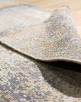 Lydia Cassandra Gray Hand Knotted Wool Rug, its intricate design partially visible, showcasing a blend of neutral grays in a hand-knotted wool construction, lending warmth and texture to the modern space.