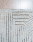 Celia Lila Ivory Hand Knotted Wool Rug, blending soft lilacs and warm ivory hues in a hand-knotted wool construction, displayed in a warmly lit interior setting.