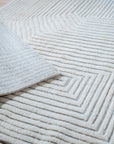 Celia Lila Ivory Hand Knotted Wool Rug, a blend of soft lila and ivory tones in a hand-knotted wool construction, displayed as part of a room setting featuring complementary décor.
