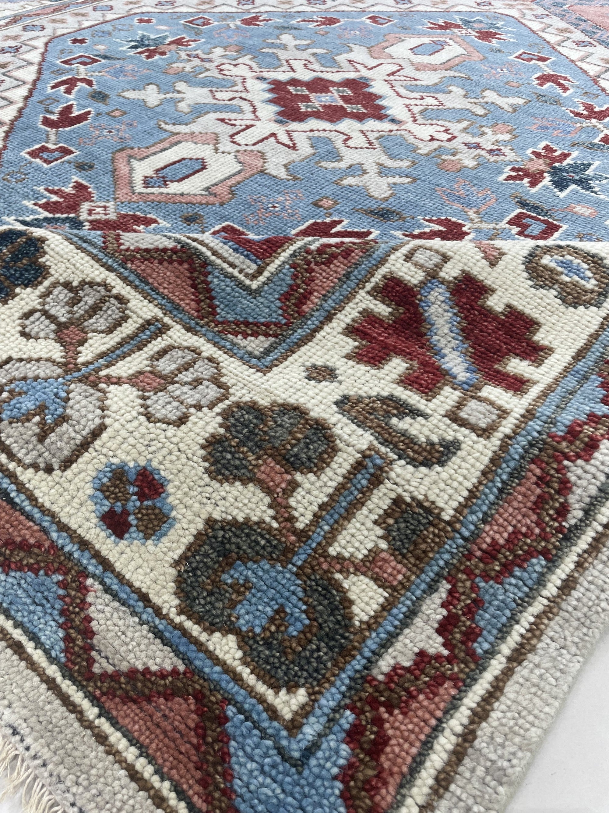 Rustic Isla Gray Hand Knotted Wool Rug, a textured grey wool rug with subtle patterns and fringed edges, lies on a light wood floor creating a warm, inviting atmosphere.