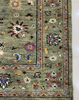 Ophelia Oriental Green Hand Knotted Wool Rug, vibrant greens and intricate patterns define this hand-knotted wool rug, adding a touch of classic elegance to a warm interior setting.