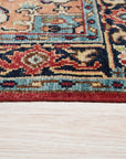 Louie Oriental Red Hand Knotted Wool Rug, showcasing intricate floral and geometric patterns in rich reds, blues, and creams, lies elegantly on a hardwood floor in a warmly lit room.