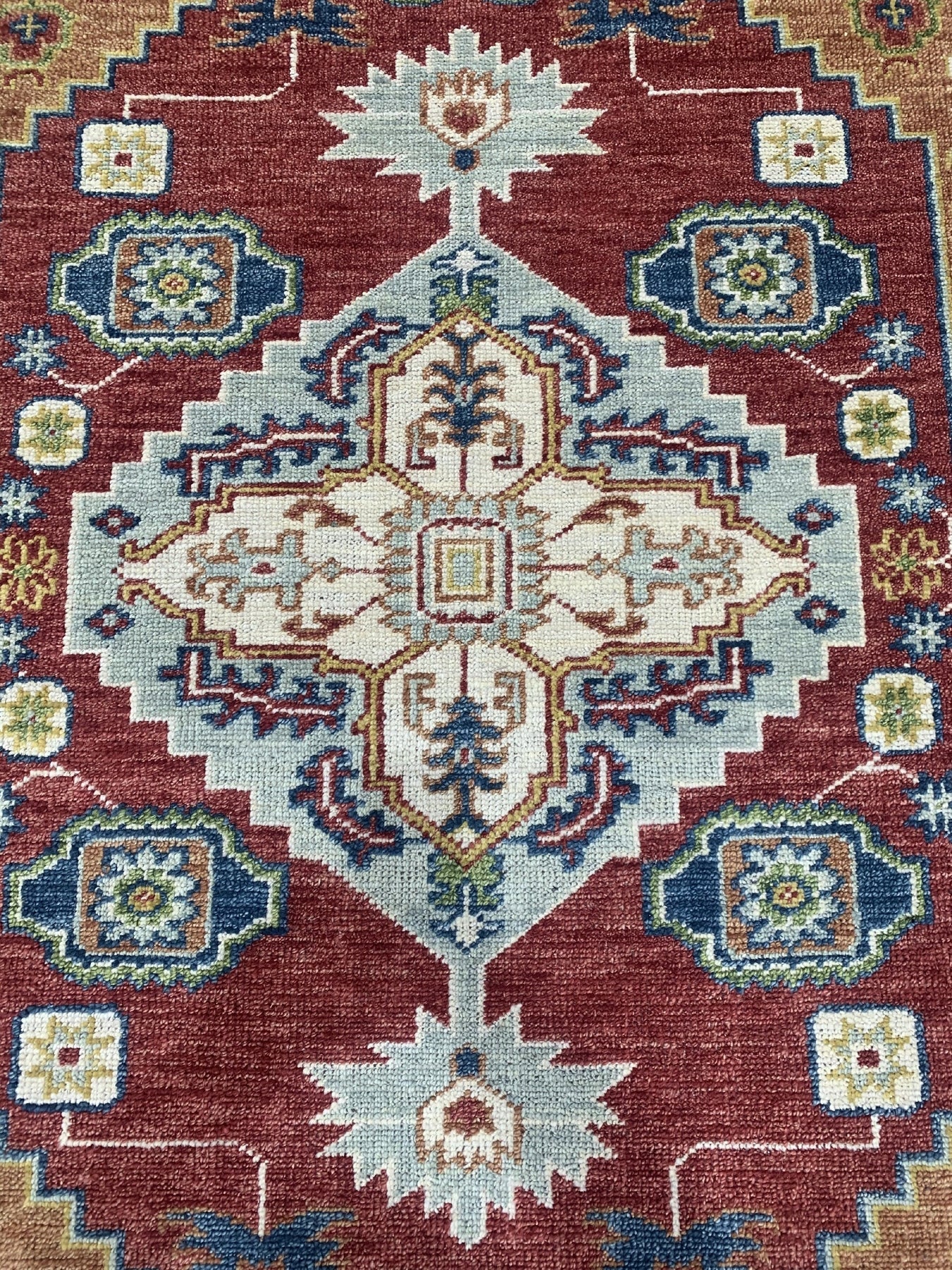 Sophie Chic Red Hand Knotted Wool Rug, showcasing intricate floral patterns woven in vibrant reds and subtle creams, creates a luxurious focal point in a warmly lit room.