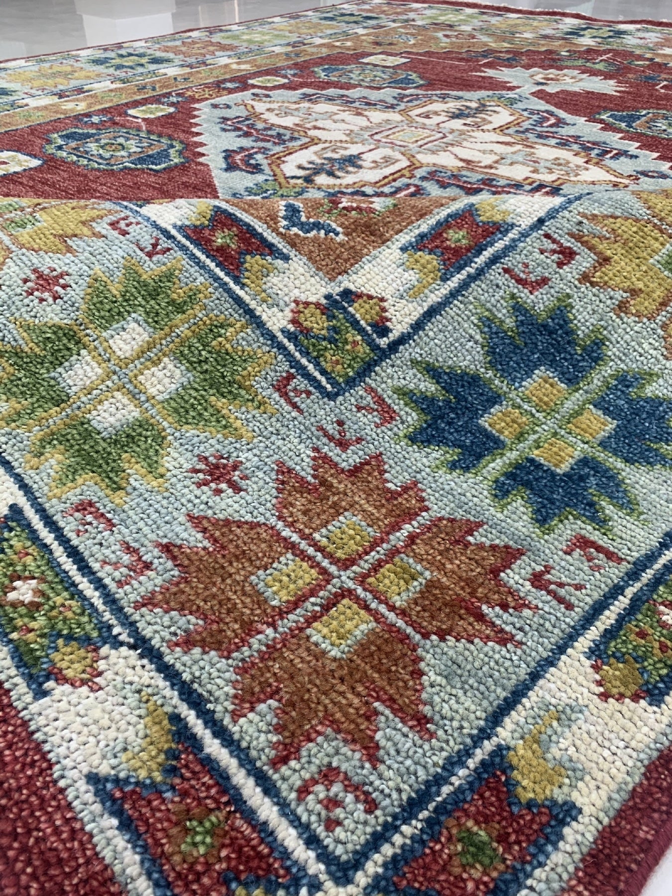 Sophie Chic Red Hand Knotted Wool Rug, vibrant reds and intricate patterns hand-knotted into luxurious wool, sits invitingly within a styled room.