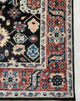 Timeless Oriental Charcoal Hand Knotted Wool Rug, displaying intricate traditional patterns in shades of charcoal, lies flat showcasing its hand-knotted wool construction.