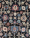 Timeless Oriental Charcoal Hand Knotted Wool Rug, a dark gray hand-knotted wool rug featuring intricate oriental patterns, displayed in a bright living space.