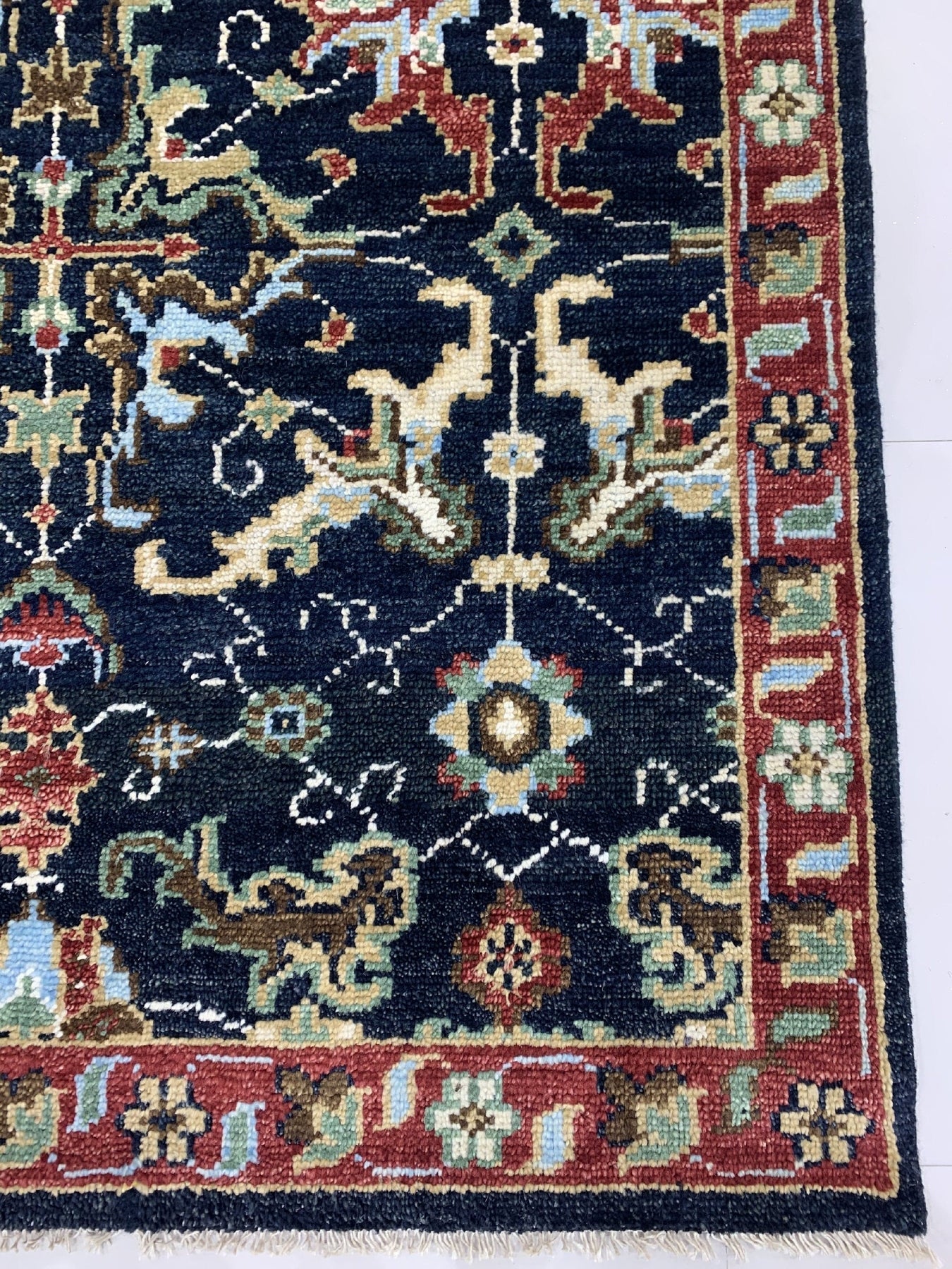 Chloe Oriental Navy Hand Knotted Wool Rug, with intricate patterns in navy and contrasting hues, laying flat with subtle variations in pile and texture suggesting hand-knotted construction.