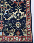 Chloe Oriental Navy Hand Knotted Wool Rug, with intricate patterns in navy and contrasting hues, laying flat with subtle variations in pile and texture suggesting hand-knotted construction.