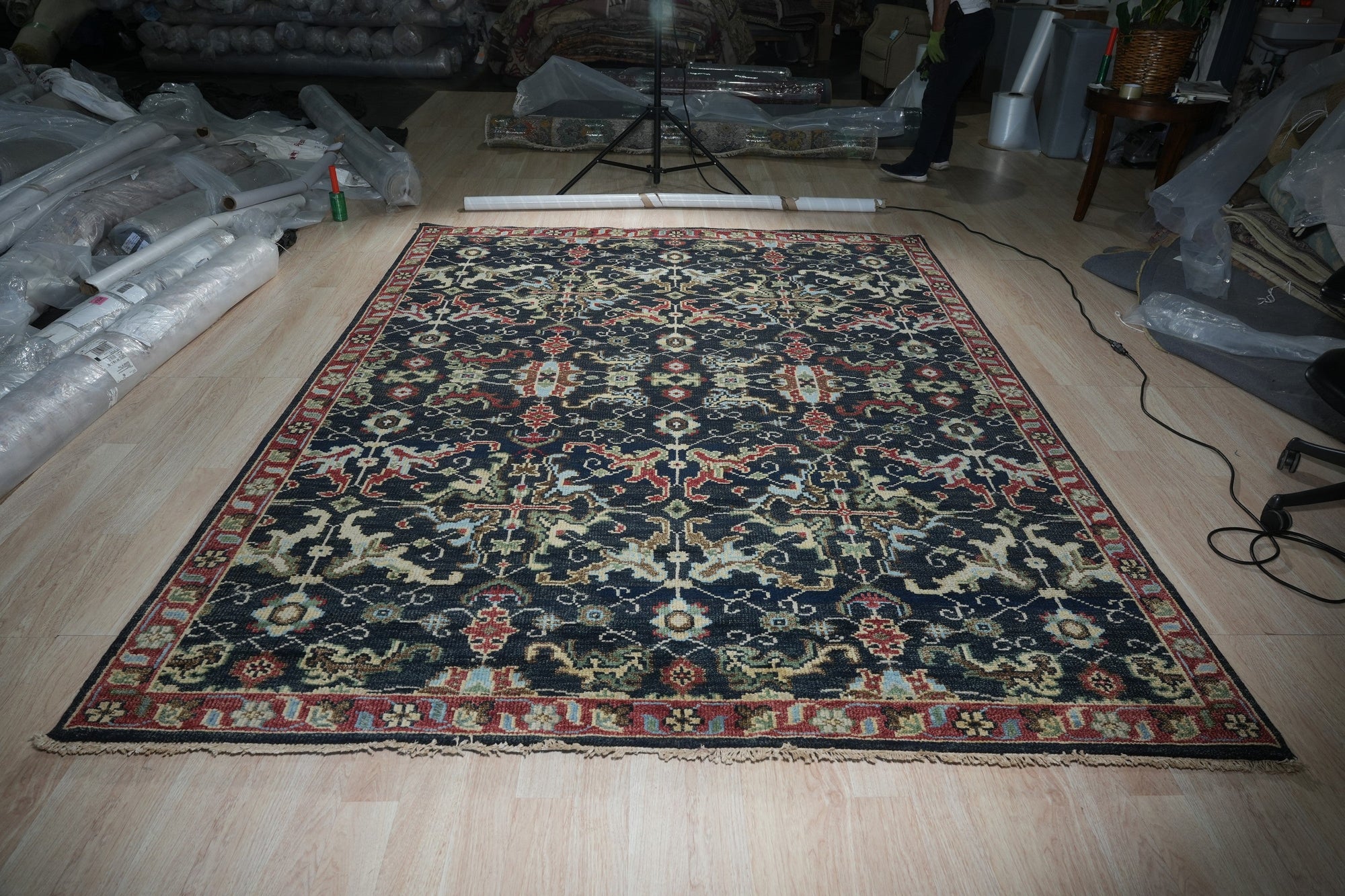 Chloe Oriental Navy Hand Knotted Wool Rug, featuring intricate navy and cream patterns, adds a touch of traditional elegance to a well-lit living space.