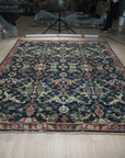 Chloe Oriental Navy Hand Knotted Wool Rug, featuring intricate navy and cream patterns, adds a touch of traditional elegance to a well-lit living space.