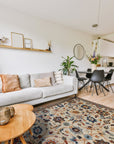 Iris Oushak Beige Hand Knotted Wool Rug, its intricate floral patterns and soft beige hues grounding a light-filled living space with modern furniture and natural accents.