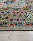 Iris Oushak Beige Hand Knotted Wool Rug, a soft beige wool rug with a traditional Oushak design, fills a warmly lit living space, showcasing its intricate knotting and subtle color variations.