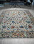 Iris Oushak Beige Hand Knotted Wool Rug, showcasing a soft beige palette and intricate Oushak pattern, sprawled invitingly on a light-wood floor.