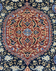 Bianca Traditional Navy Hand Knotted Wool Rug, showcases its intricate traditional pattern in deep navy blue and ivory tones, hand-knotted construction visible, softening a warmly lit space.