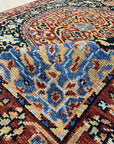 Bianca Traditional Navy Hand Knotted Wool Rug, displaying intricate patterns in deep navy and lighter blues, softening the well-lit living space with classic elegance.