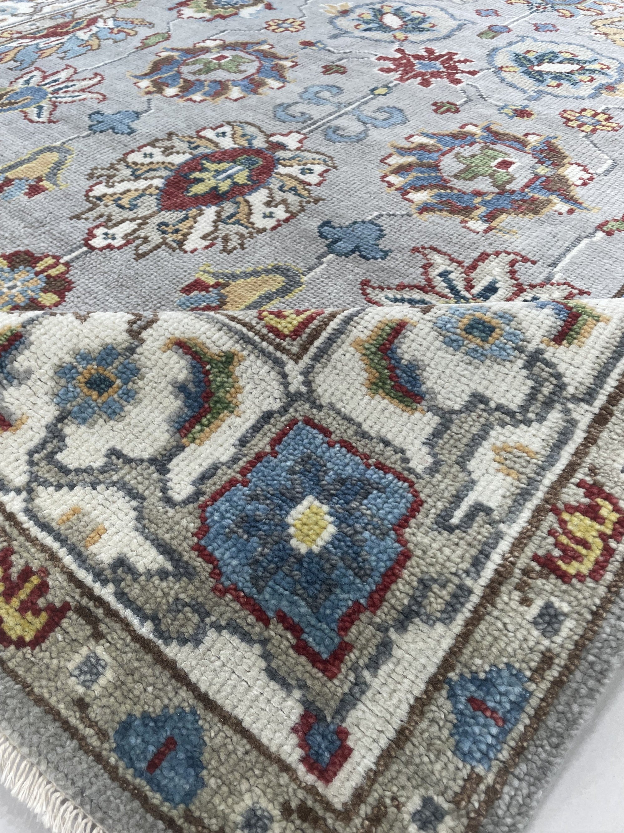 Enchanting Oriental Gray Hand Knotted Wool Rug, displaying intricate patterns in shades of gray, likely in a room setting to show scale and possible coordination with furniture.
