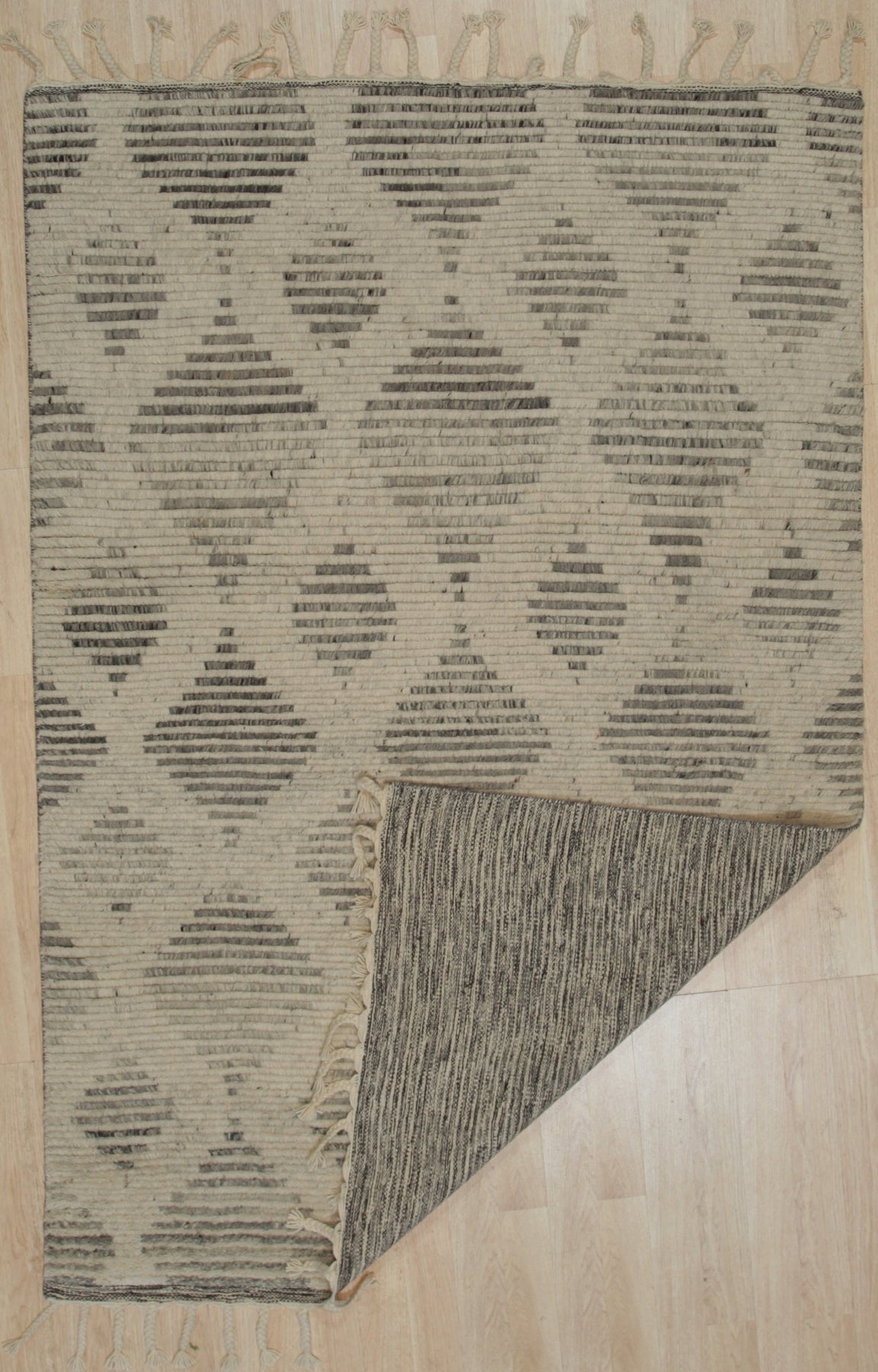 Dazzling Ophelia Beige Hand Knotted Wool Rug, a beige wool rug with intricate hand-knotted detailing, displayed within a room setting.
