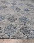 Zinnia Kira Multicolor Hand Tufted Wool Rug, vibrant blend of colors and textures pops against a light wooden floor. Detailed hand-tufted construction reveals intricate floral motifs and geometric patterns. Warmth and artistry radiate from this wool rug, inviting touch and enhancing the room's décor.