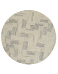 Kira Cassandra Gray Hand Tufted Wool Rug, a textured grey wool rug with a subtle pattern, complementing a modern living room setting with neutral furniture and warm lighting.