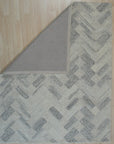 Kira Cassandra Gray Hand Tufted Wool Rug, soft gray tones and subtly textured wool pile offer warmth and understated elegance in a well-lit interior setting.