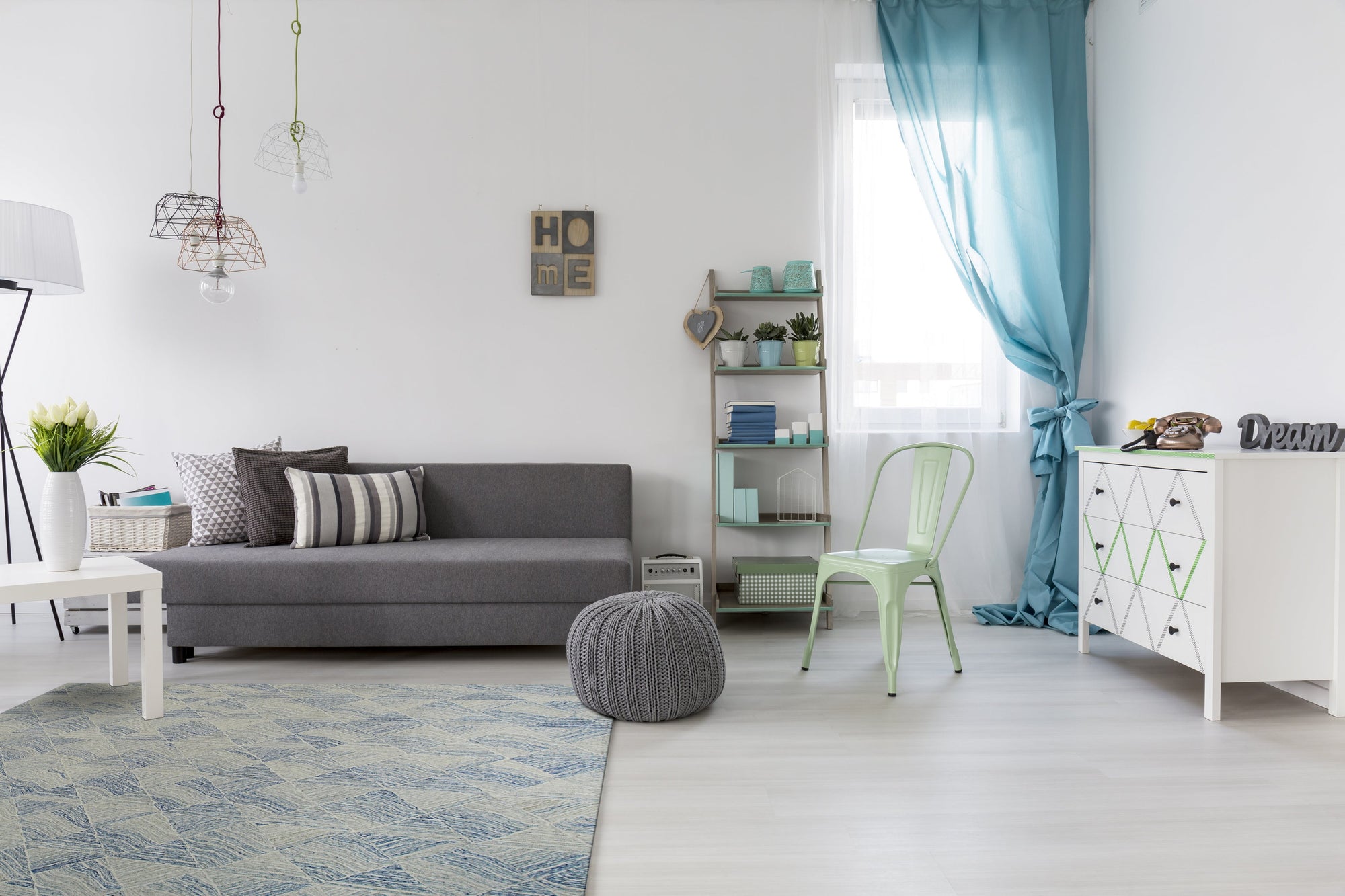 Para Nadia Blue Hand Tufted Wool Rug, a textured blend of cool blues and creams creating a dynamic abstract pattern, layered under a mid-century modern living room setting with sleek furniture.