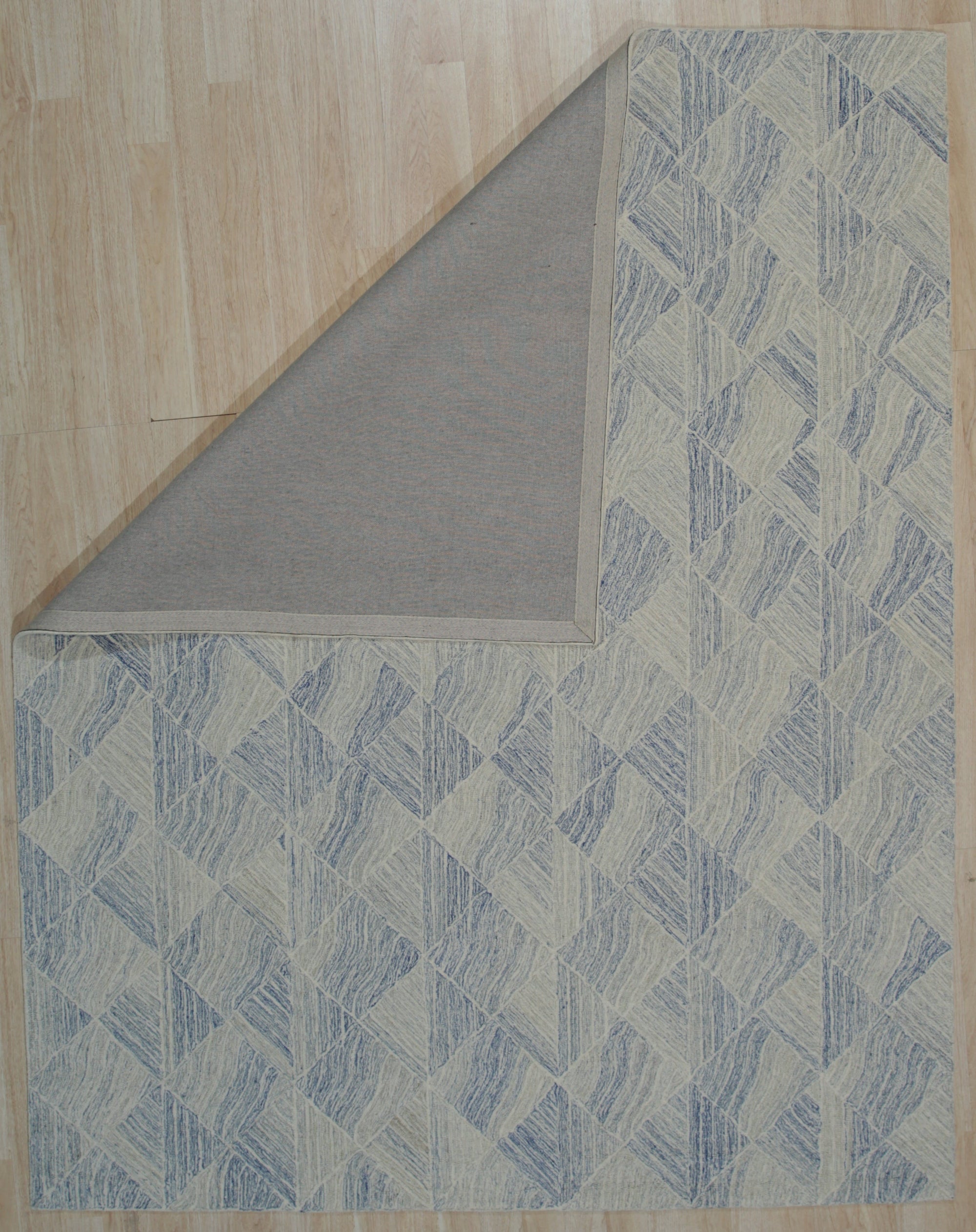 Para Nadia Blue Hand Tufted Wool Rug, a textured blue wool rug with a modern geometric design, seen in a bright interior setting with neutral furniture.