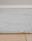 Para Nadia Blue Hand Tufted Wool Rug, a serene blue wool rug with a textured, abstract design, displayed as part of a room setting showcasing its calming presence.