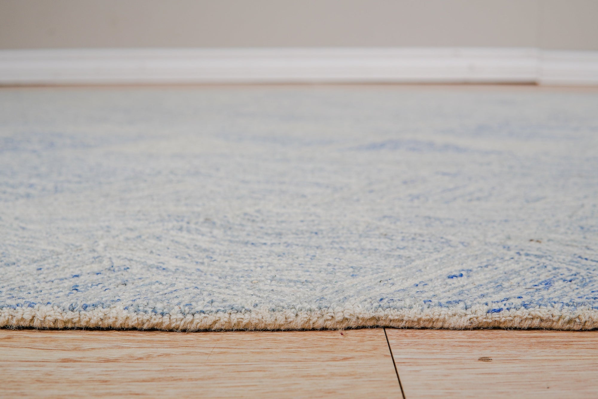 Trara Nadia Blue Hand Tufted Wool Rug, a blue hand-tufted wool rug with a geometric pattern, displayed in a living room setting.