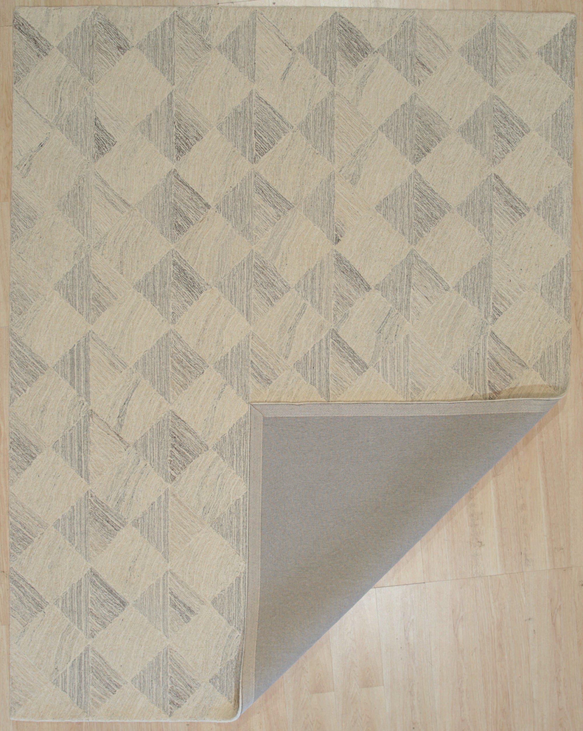 Warm Harlow Gray Hand Tufted Wool Rug, seen in a room setting with neutral walls, displaying its textured gray wool construction and plush pile.