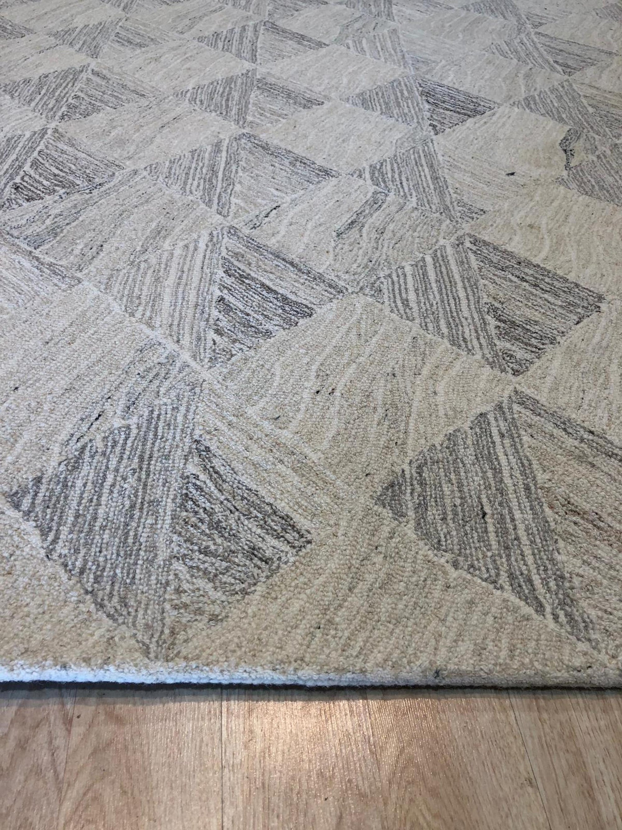 Warm Harlow Gray Hand Tufted Wool Rug, showcasing its plush texture and subtle gray tones in a living room setting. Soft light highlights the rug's hand-tufted construction and inviting warmth.
