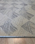 Warm Harlow Gray Hand Tufted Wool Rug, showcasing its plush texture and subtle gray tones in a living room setting. Soft light highlights the rug's hand-tufted construction and inviting warmth.
