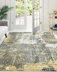 Chic Iris Gold Hand Knotted Wool Rug, its swirling gold and cream patterns catching the light, sits elegantly on a dark hardwood floor. The hand-knotted construction is evident in the subtle texture, creating a warm and inviting focal point in the room.