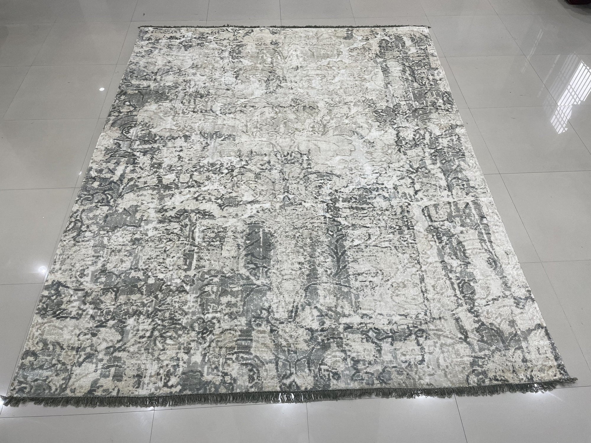 Sarrah Penelope Gray Hand Knotted Wool Rug, showcasing intricate details of its hand-knotted construction and subtle gray tones, displayed in a well-lit setting to highlight its texture and pattern.