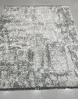 Sarrah Penelope Gray Hand Knotted Wool Rug, showcasing intricate details of its hand-knotted construction and subtle gray tones, displayed in a well-lit setting to highlight its texture and pattern.