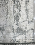 Sarrah Penelope Gray Hand Knotted Wool Rug, its intricate design unfolding across a living room floor, adding subtle warmth and texture to the space.